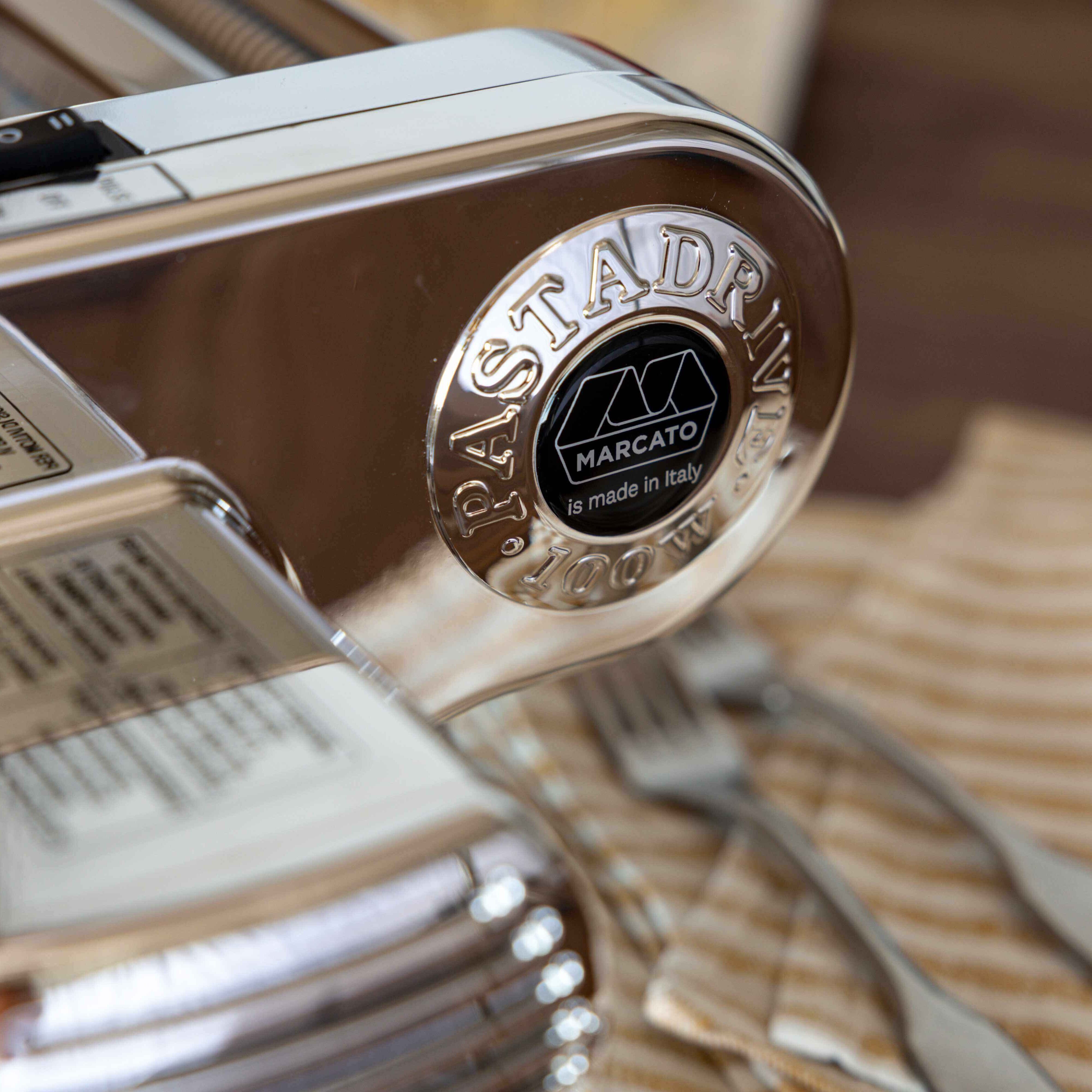Metallic pasta maker with 'Pastadrive' branding on a wooden surface.