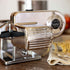 Pasta maker with fresh pasta on a kitchen counter