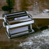 Marcato Atlas 180 pasta maker on a wooden table with flour, rustic kitchen setting.