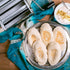 Marcato Atlas 180 pasta maker on a blue textile, next to homemade pitta breads and a dip.