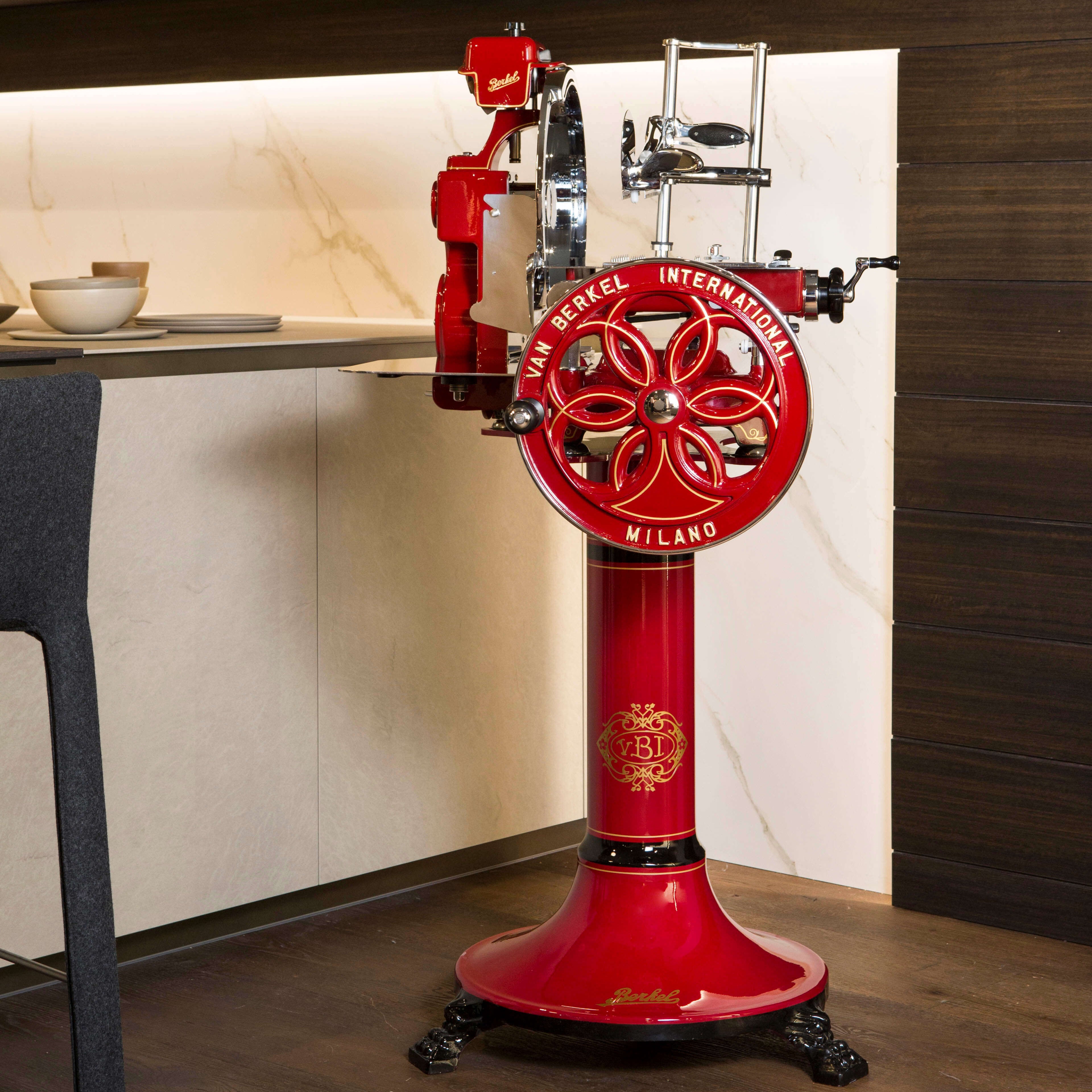 Red Berkel Volano B114 flywheel machine on the matching stand in a modern kitchen