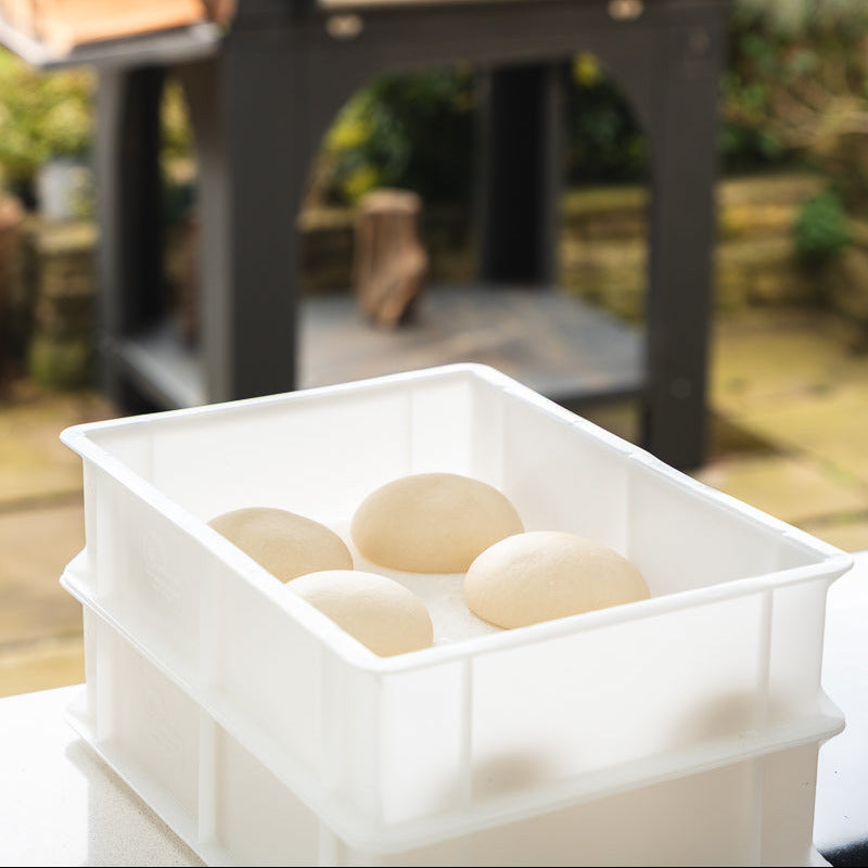 Pizza dough in white dough proofing boxes.