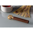 Marcato La Rotella pasta cutter with wooden handle and brass toothed wheel in front of fresh pasta