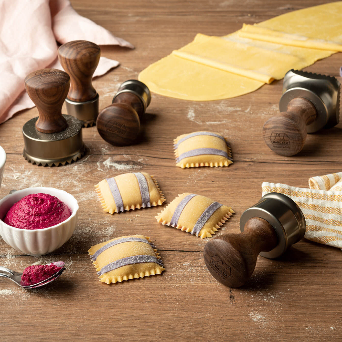 Ravioli and Marcato Design Round Ravioli stamps on a wooden work surface with fresh pasta in the background