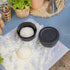 Charcoal Spetina dough boxes on a stainless steel board on a blue work surface with flour