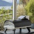 ZiiPa Piana wood fired oven with a Donato pellet dispenser attached in a green, outdoor setting