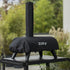 ZiiPa Piana pizza oven in a Sacco protective cover on a Vallone pizza oven trolley in a green, outdoor setting