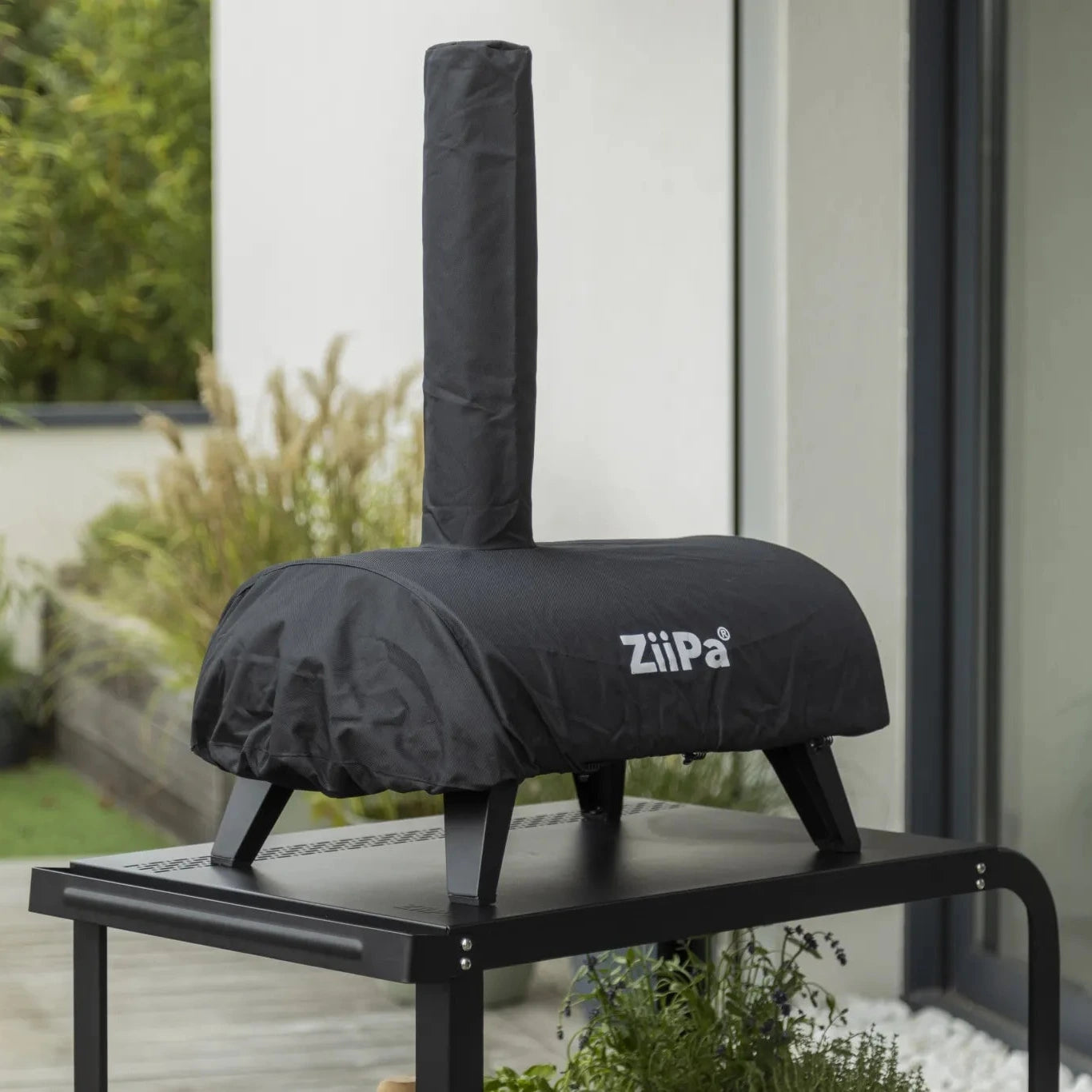ZiiPa Piana pizza oven in a Sacco protective cover on a Vallone pizza oven trolley on an outdoor patio