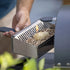 Person starting a fire with ZiiPa beech wood pellets and a fire starter in the fuel drawer for the Piana pizza oven