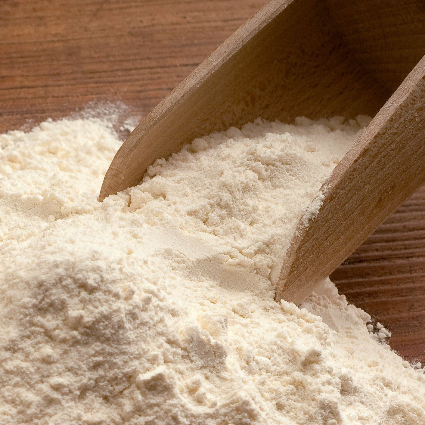 Wooden scoop picking up flour