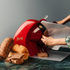 Person using a red Berkel Home Line Plus 250 slicer to cut bread on a dark surface with a gray background.