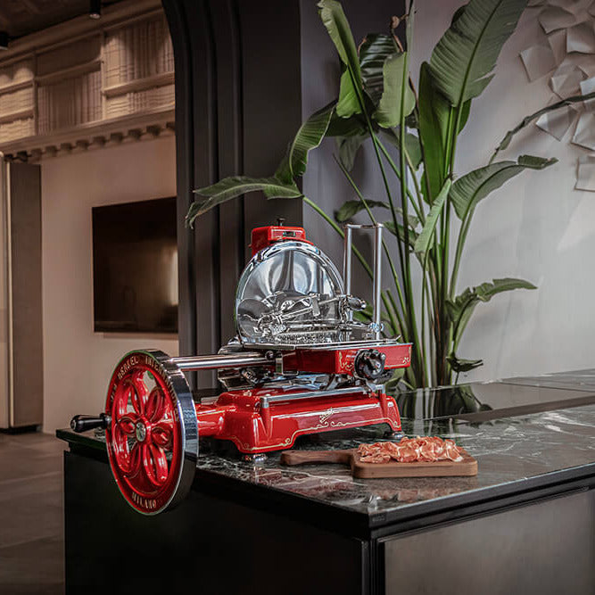 Red Berkel Volano B114 on a countertop, next to a Volano presenting board with cut meat on top